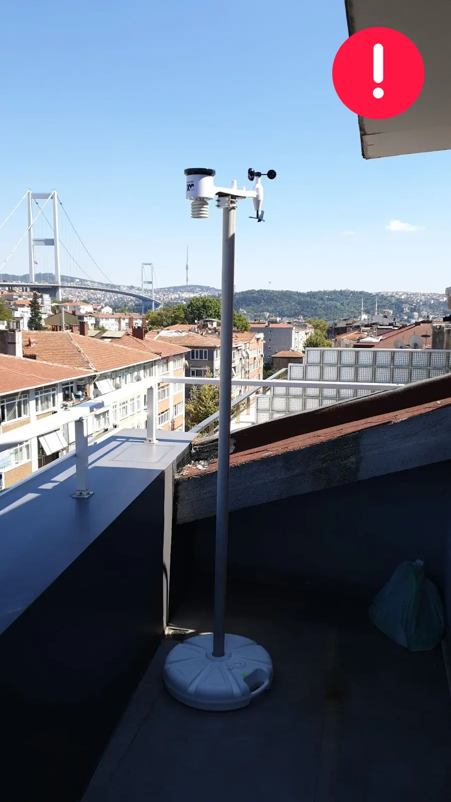 WeatherXM station installed on a balcony close to a wall and roof
